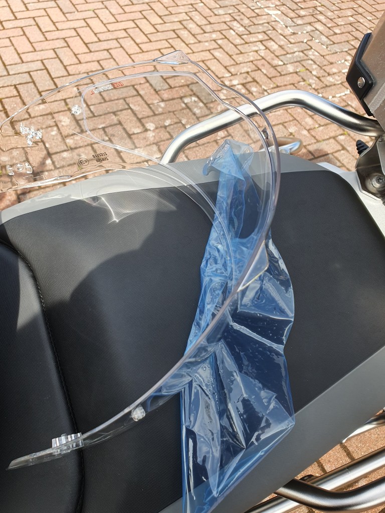 Wider shot of visor from safety helmet with protective film being removed